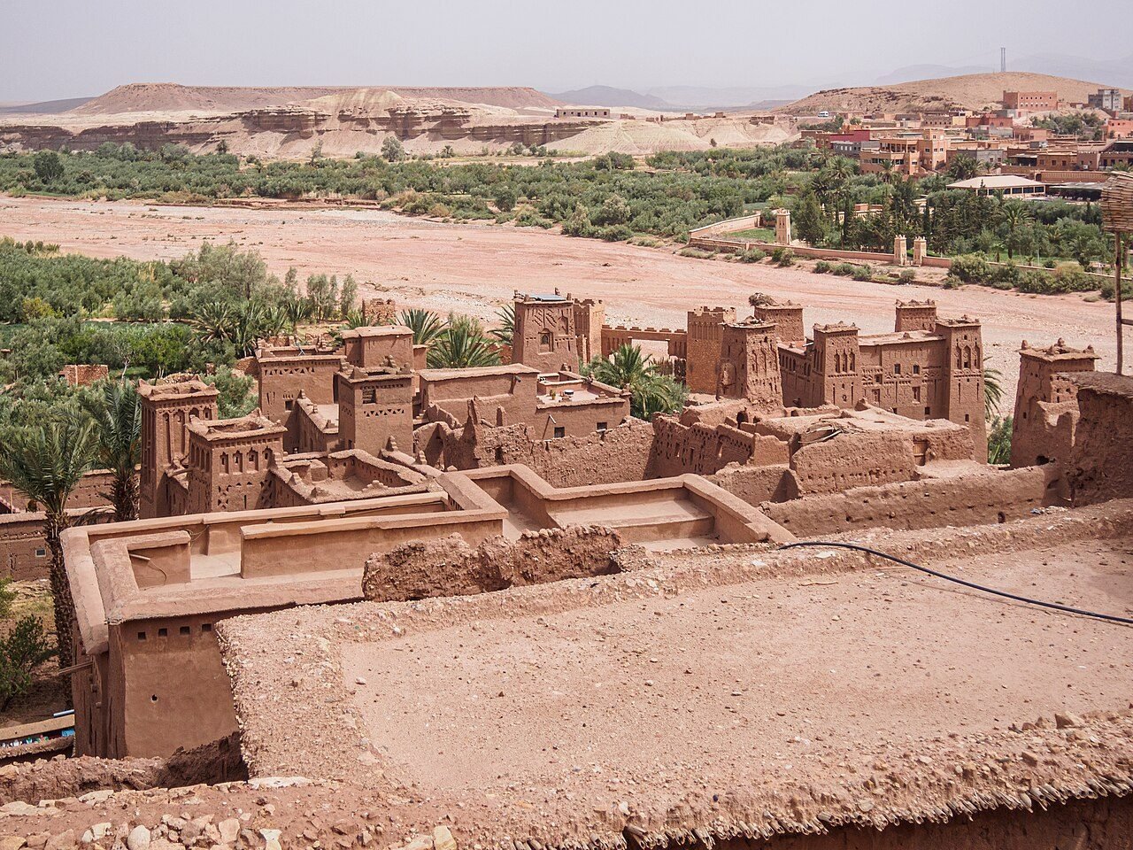 The earthen ksar of Ait Benhaddou rising on a hill above the Ounila River in golden afternoon light
