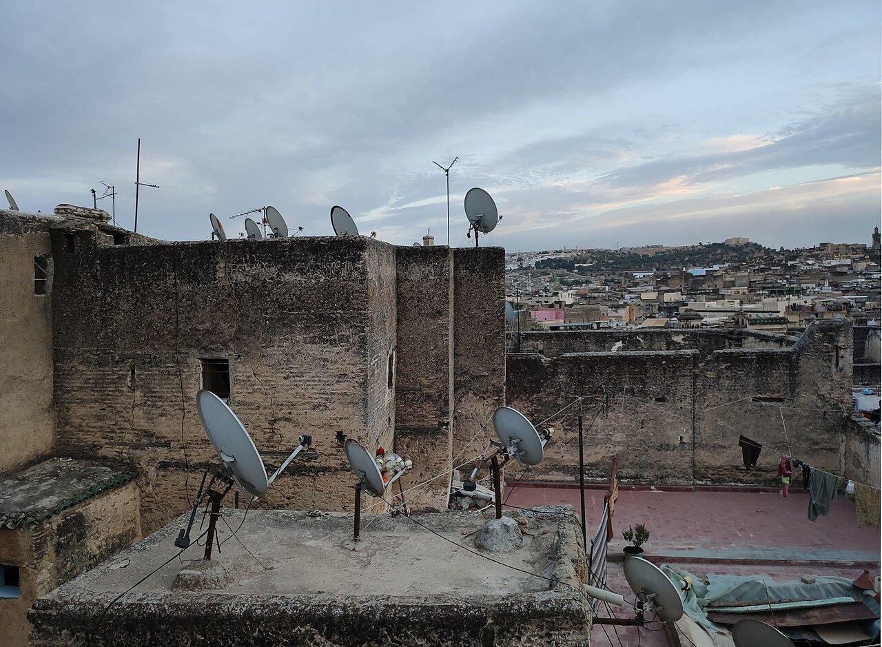 Rooftop view over the dense houses and minarets of the Fes el Bali medina with the surrounding hills