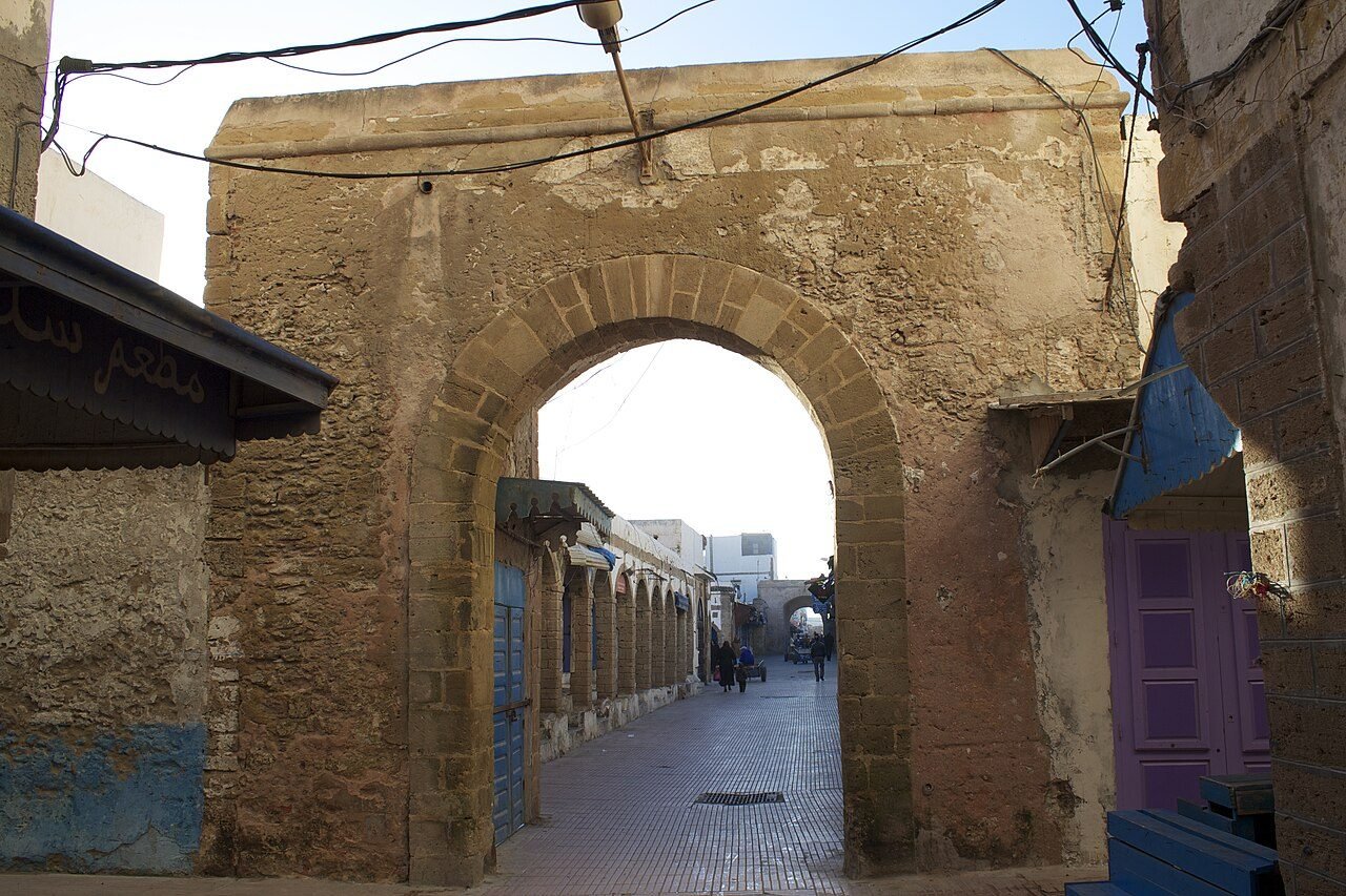 Blue fishing boats in Essaouira harbour with the stone ramparts of the Skala du Port behind