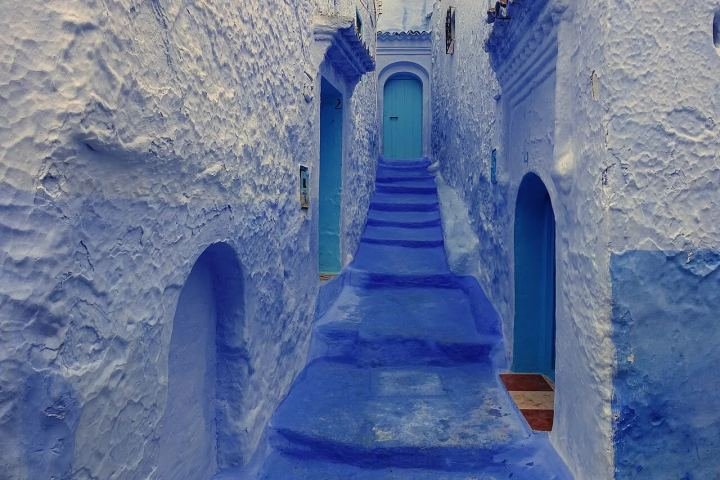 Blue-painted street with steps and flower pots in Chefchaouen