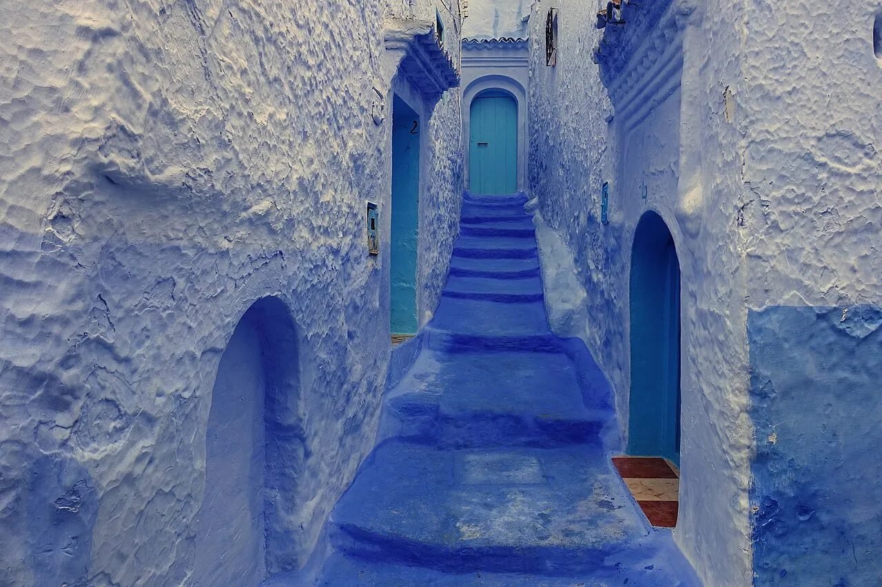 Blue-painted street with steps and flower pots in Chefchaouen