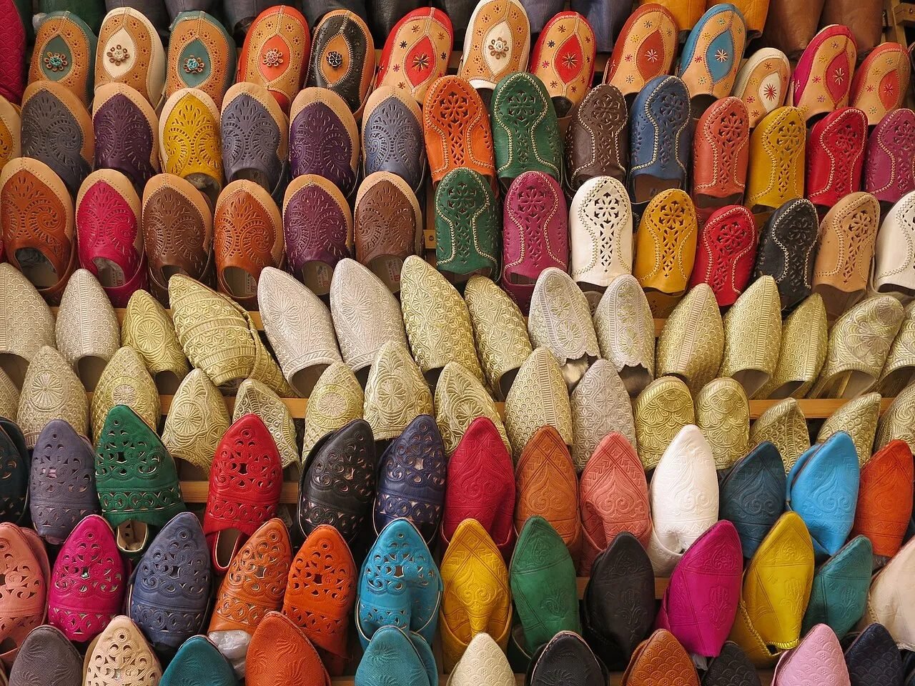 Pairs of colourful leather babouche slippers on display in a Moroccan souk